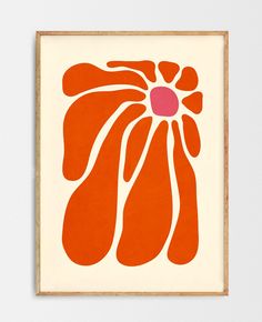 an orange and pink flower is on the wall in front of a white wall with a wooden frame