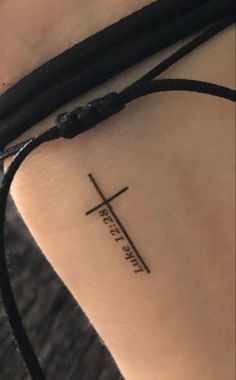 a small cross tattoo on the wrist