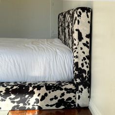 a black and white cow print headboard on a bed