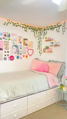 a bedroom with white walls and lots of pictures hanging on the wall above the bed