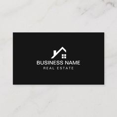 a real estate logo on a black and white business card with a house silhouette in the middle