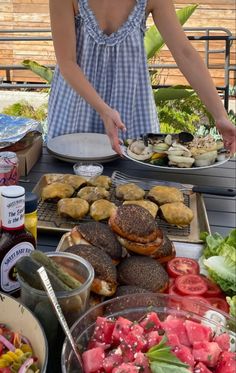 a woman standing in front of a table filled with food