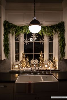 a kitchen with christmas decorations on the window sill and lights in the windowsill