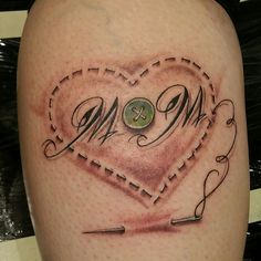 a heart tattoo with the word mom on it and two sewing needles in the shape of a heart