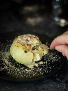 a person is spooning some food out of a black plate