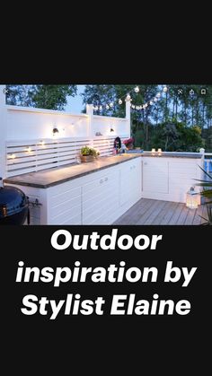 an outdoor kitchen is lit up with string lights and potted plants on the counter