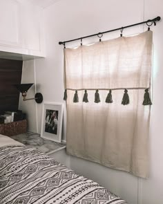 a bedroom with a bed, window curtain and pictures on the wall in front of it