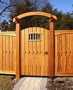 a wooden gate with a brick walkway leading to it