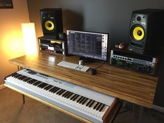 there is a keyboard and two speakers on the table next to each other in this room