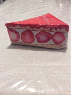 an origami box sitting on top of a white tablecloth covered bedding