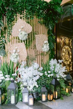 flowers and candles are lined up in front of a bamboo screen