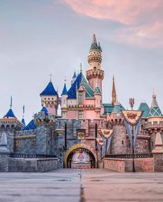 the entrance to disneyland's sleeping beauty castle is shown in this photo taken at sunset