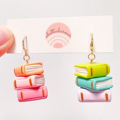 a pair of earrings with books on them