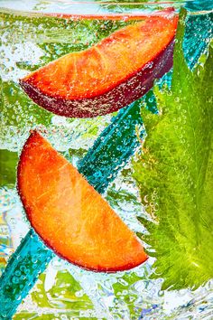 two slices of orange and green leaf floating in water