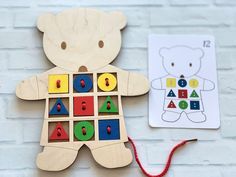 a wooden bear with letters and numbers on it next to a coloring book