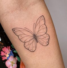 a small butterfly tattoo on the arm