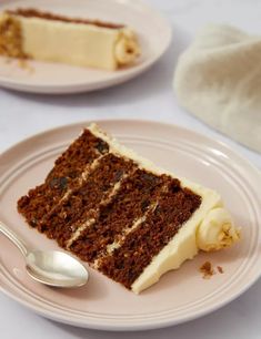 a piece of cake on a plate with a spoon next to it and another slice in the background