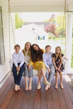 a group of people sitting on a porch swing