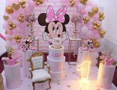 a minnie mouse themed birthday party with pink and gold decorations, balloons, and cake