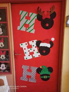 a door decorated with mickey mouse and other holiday decorations, including santa's helper hats