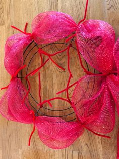 a pink mesh wreath on a wooden floor