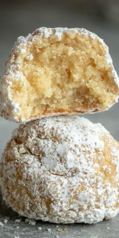 two powdered sugar donuts stacked on top of each other with one bite taken out