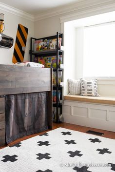 a bedroom with a bunk bed, bookshelf and window