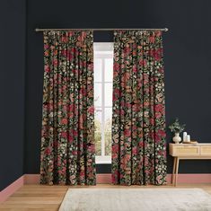 a living room with black walls and floral curtains