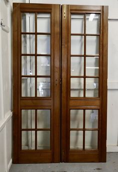 two wooden doors with glass panels in a room