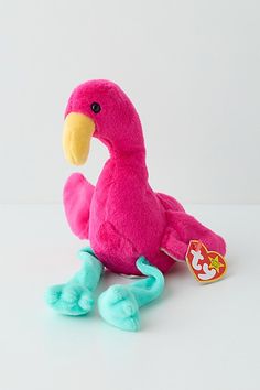 a pink stuffed bird sitting on top of a white table