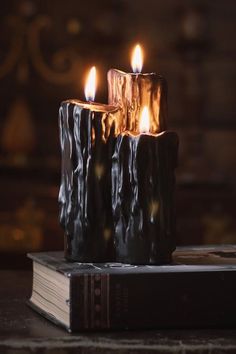 three lit candles sitting on top of a book