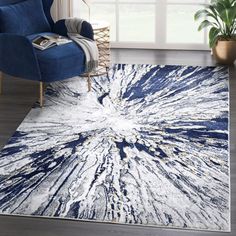 a blue and white area rug with an abstract design on the floor in front of a window