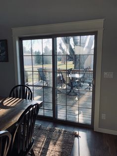 a dining room table with chairs and sliding glass doors