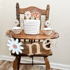 a cake and cupcakes on a wooden chair with the word me spelled out