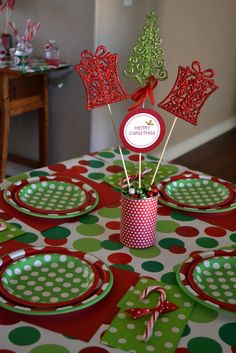 a table set for christmas with plates, candy canes and decorations on top of it