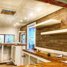 an empty kitchen with wooden counter tops and white cabinets in the middle of the room