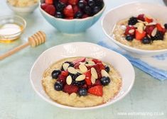 two white bowls filled with oatmeal and fruit on top of a table