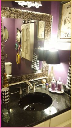 a bathroom sink sitting under a mirror next to a black and white checkered counter top