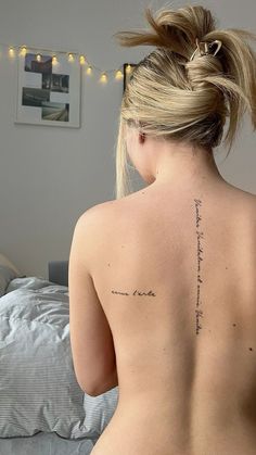 the back of a woman's body with writing on her left shoulder and right arm