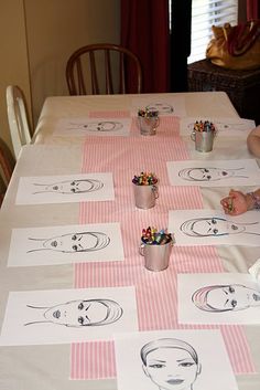 a child sitting at a table with some drawings on it