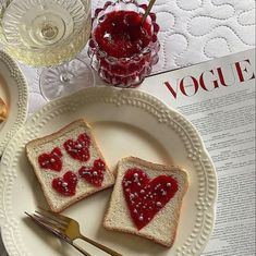 two pieces of toast with jam on them sitting on a plate next to a glass of wine