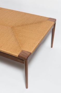 a close up of a wooden table on a white surface with no one around it