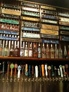 there are many different types of beer on the shelves in this bar, and one is empty