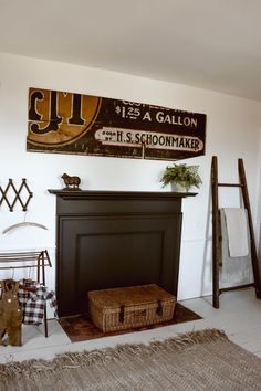 there is a fireplace in the living room with signs on the wall above it and a basket next to it