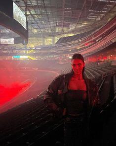 a man standing in the middle of a stadium with red lights on his face and shoulders