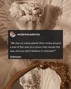 an angel statue next to a mirror with a quote on it