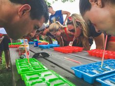 a group of people standing around a table filled with plastic trays