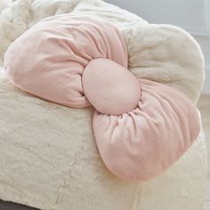 a pink and white comforter on top of a bed