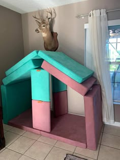 a house made out of cardboard with a deer head on the wall