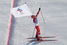 a person on skis holding up a flag in the middle of an obstacle course